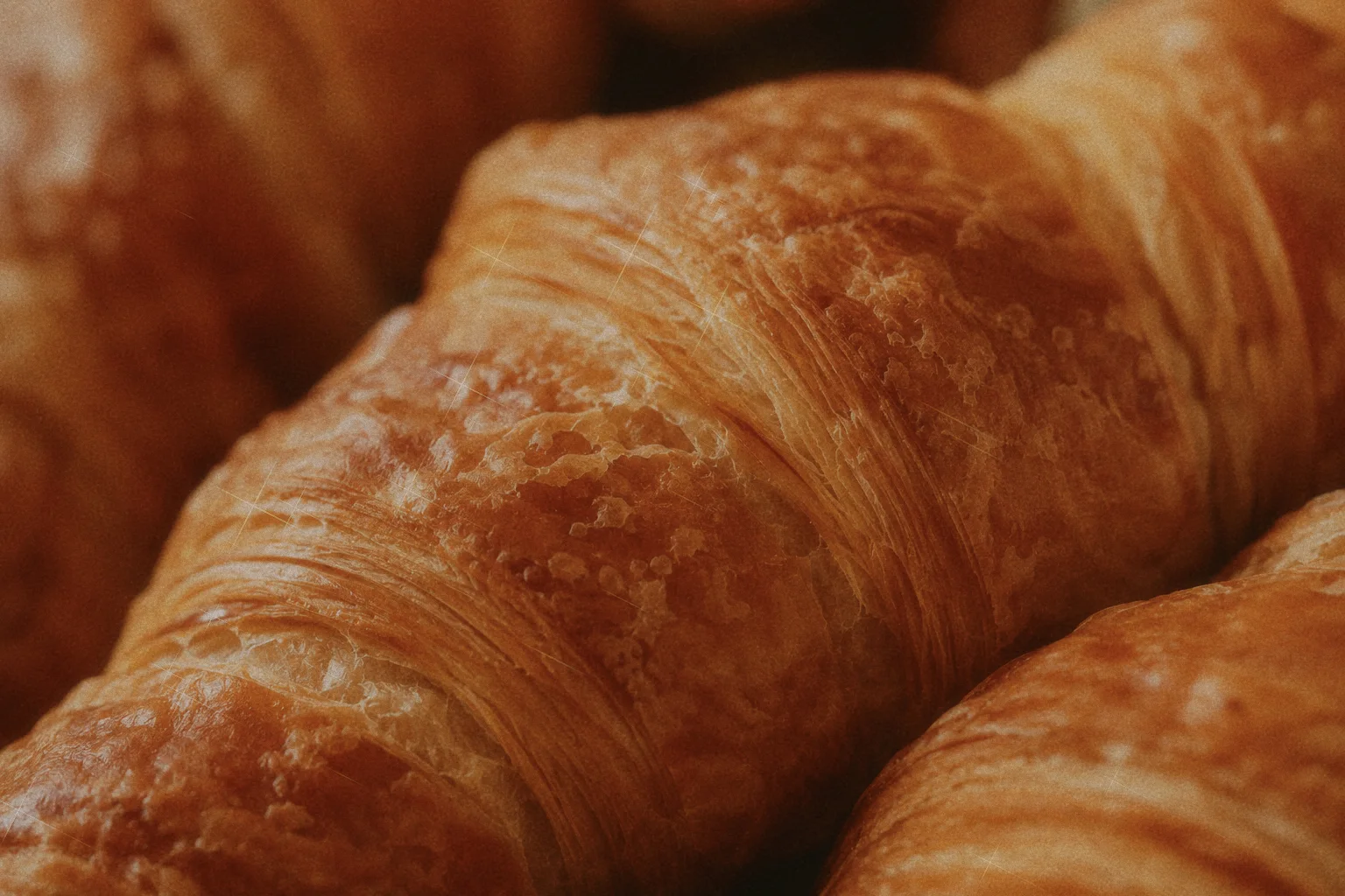 Close-up of golden croissants showing their crisp, layered pastry surfaces