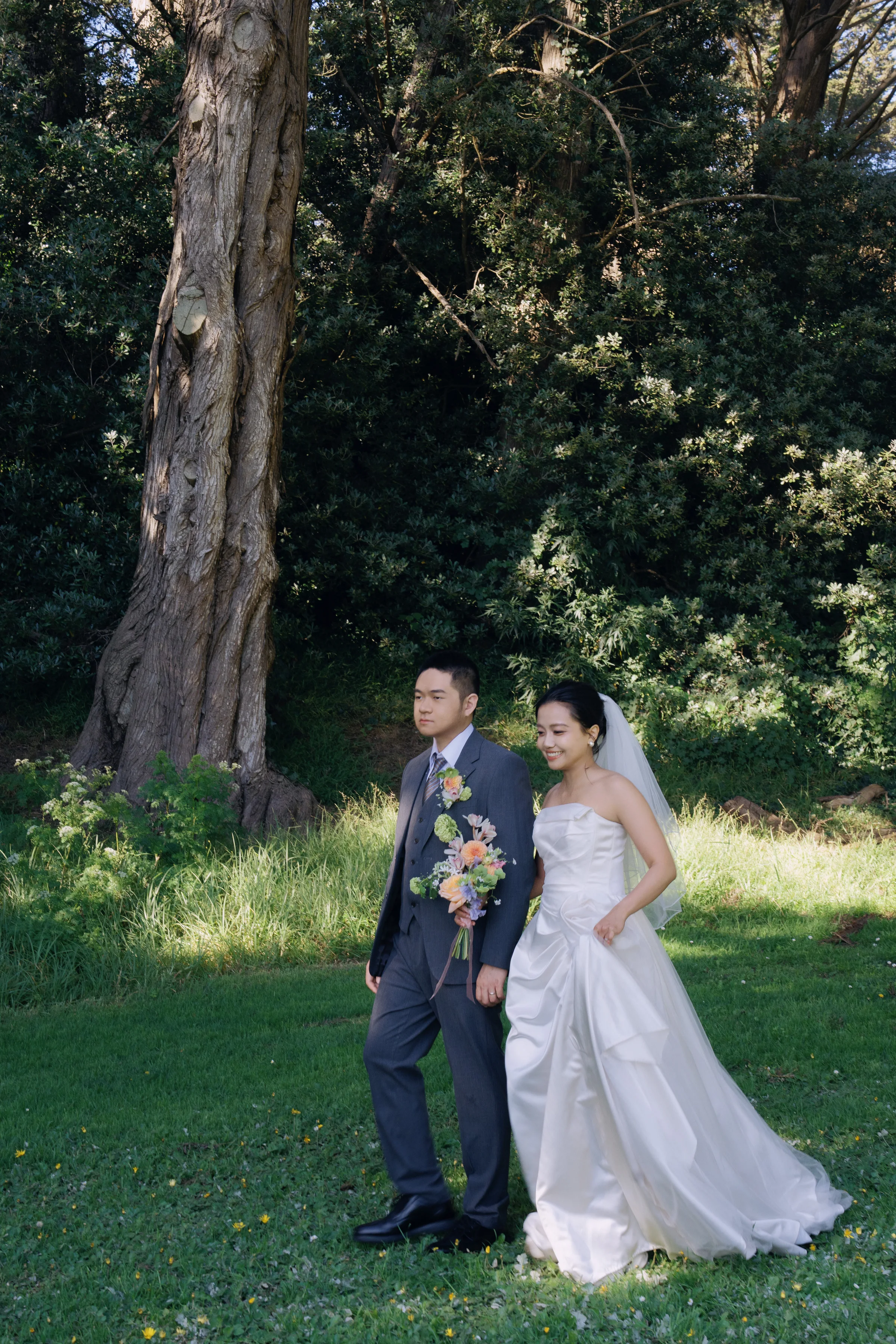Couple walking together across a sunlit garden lawn