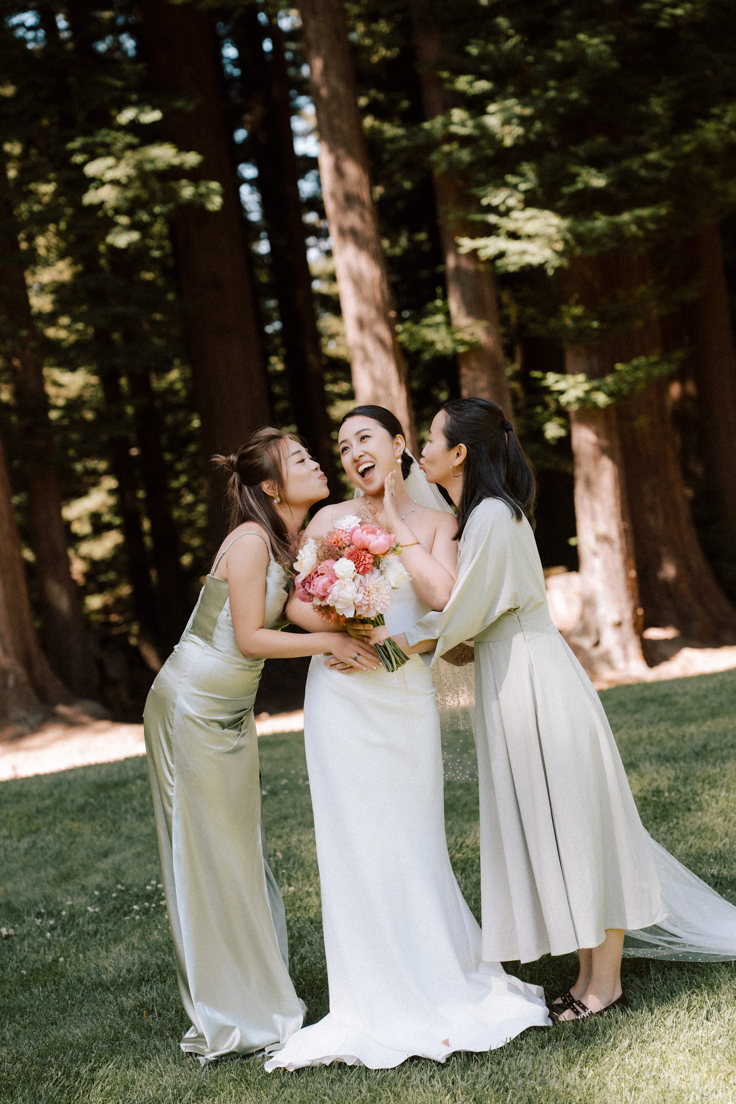 Bride laughing with bridesmaids in neutral gowns in the redwood grove