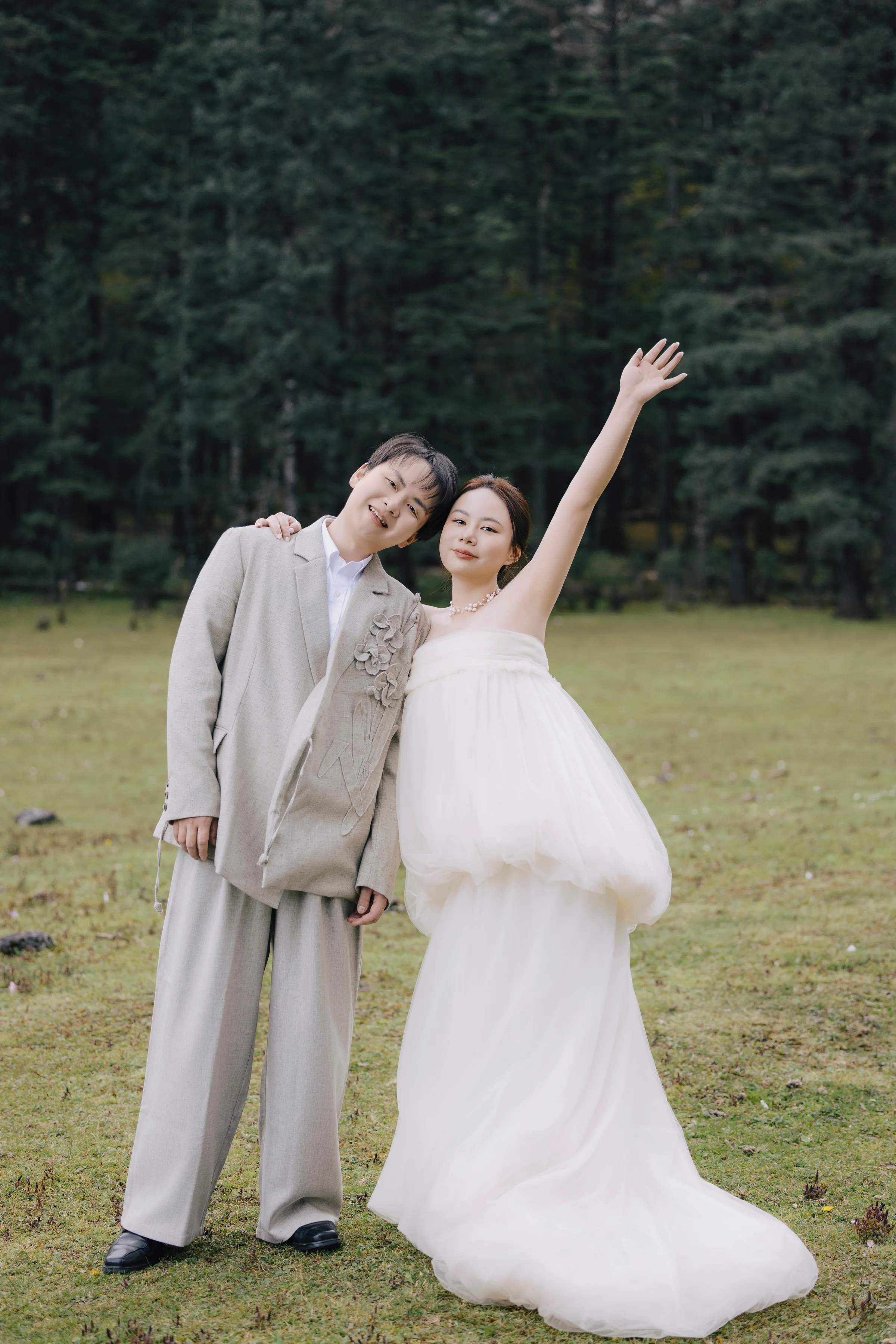 Couple celebrating with arms raised in an open meadow