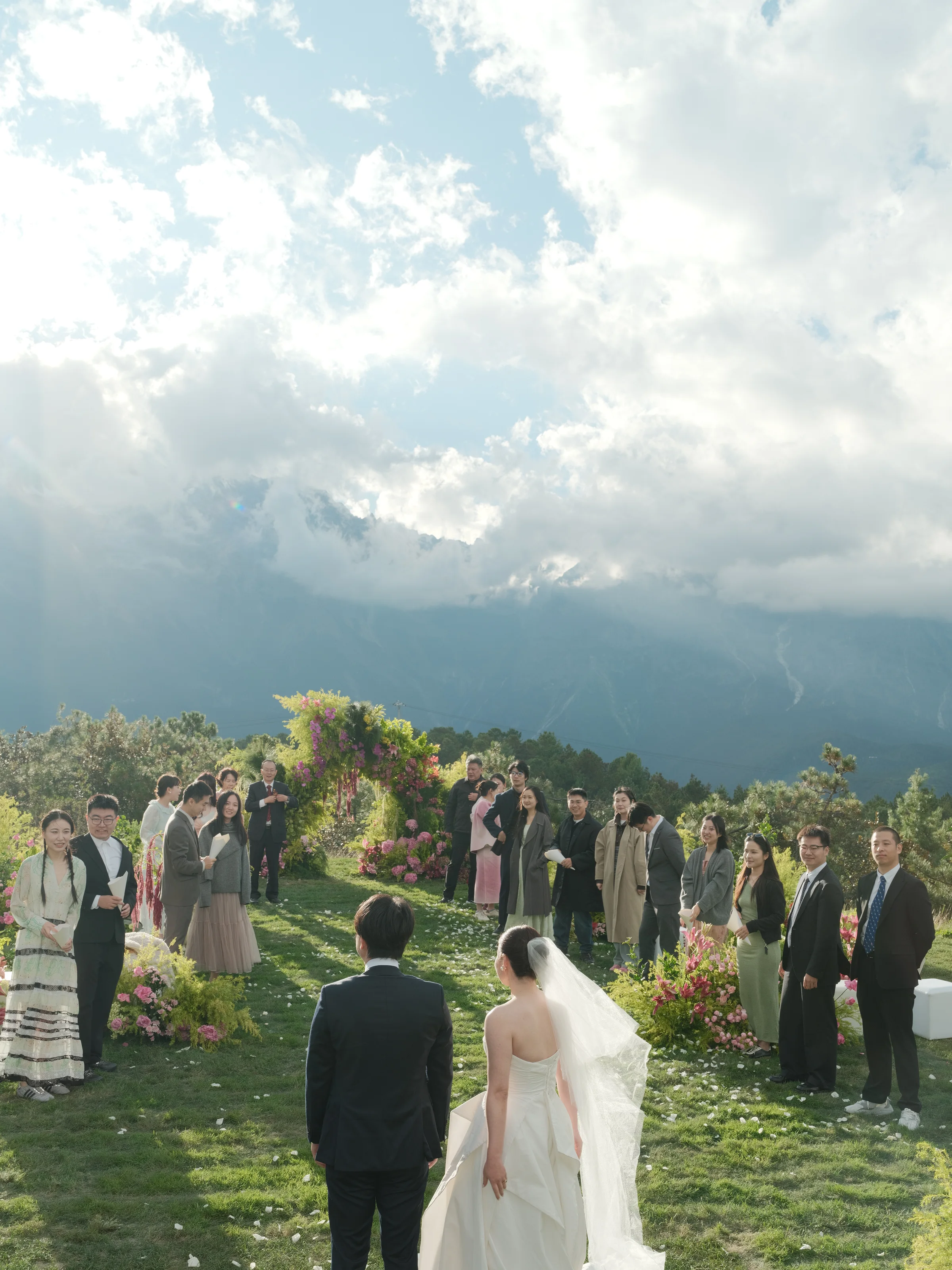 Couple's recessional down the aisle between seated guests with mountains behind