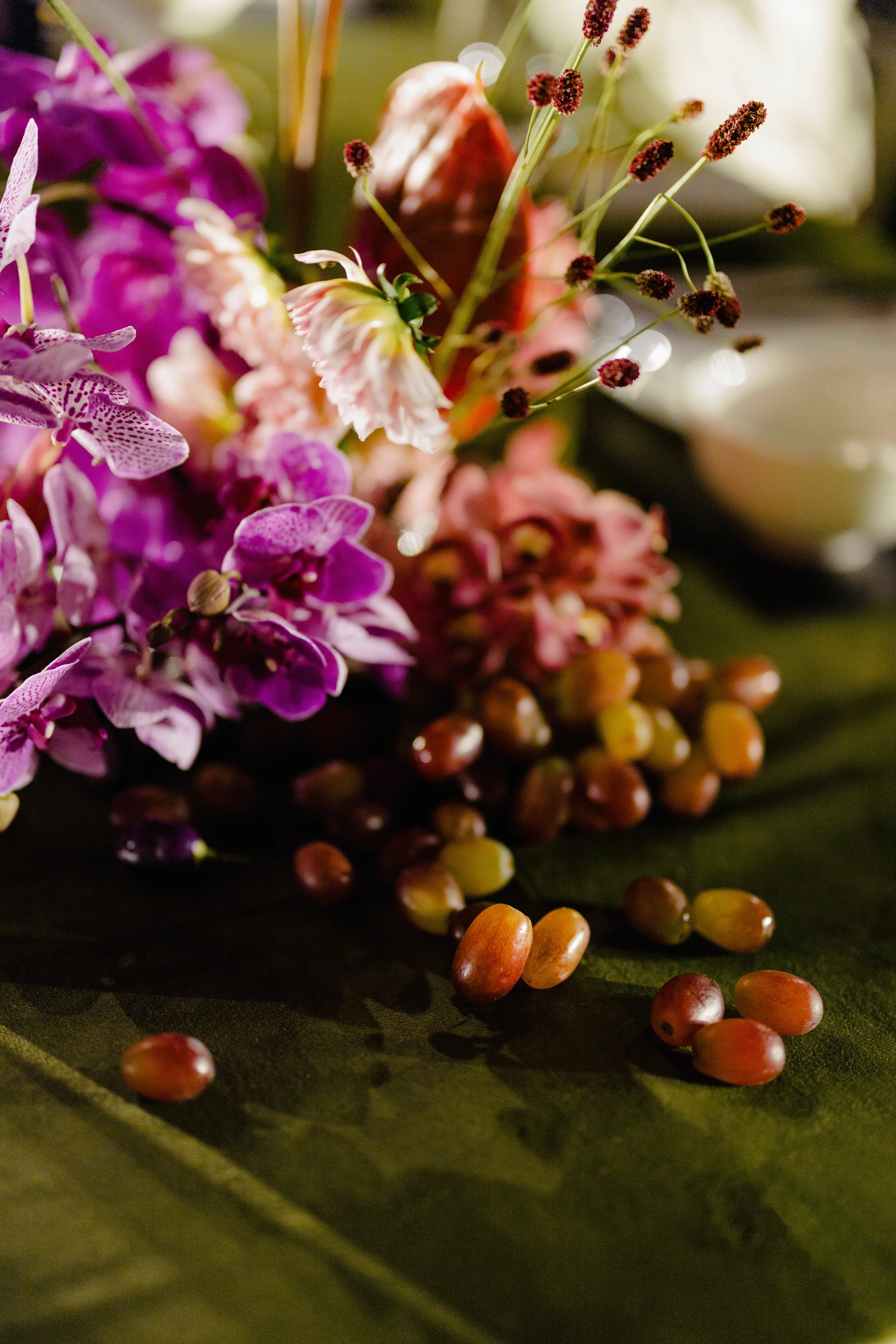 Magenta floral centerpiece with berries on a reception table