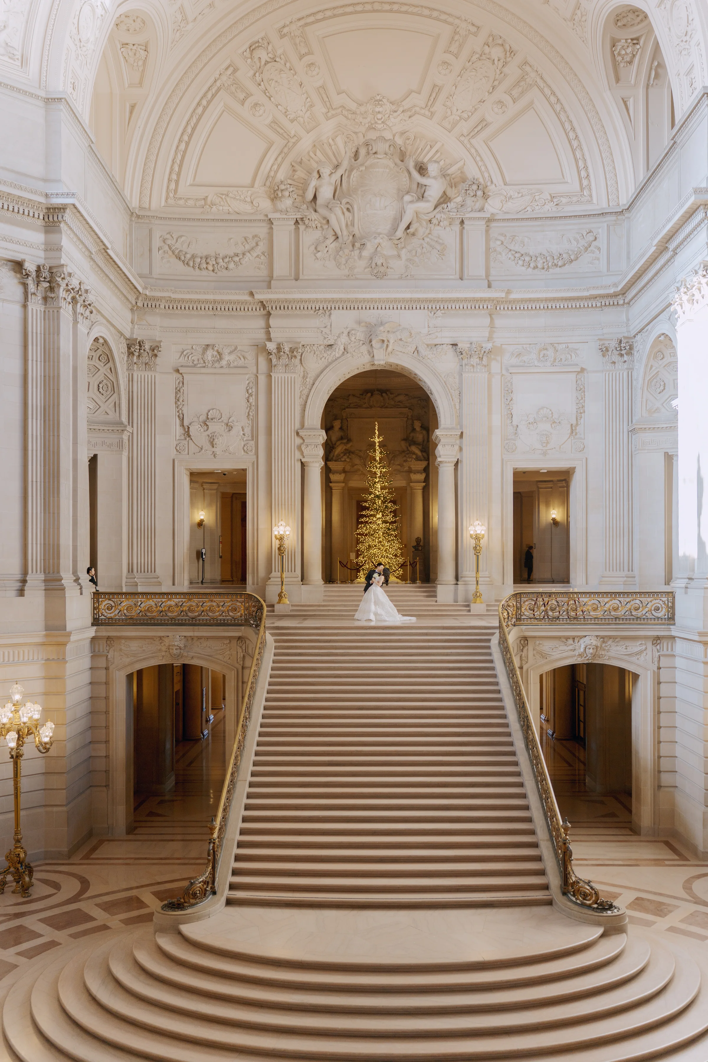 The bride standing at the top of the vast empty marble staircase