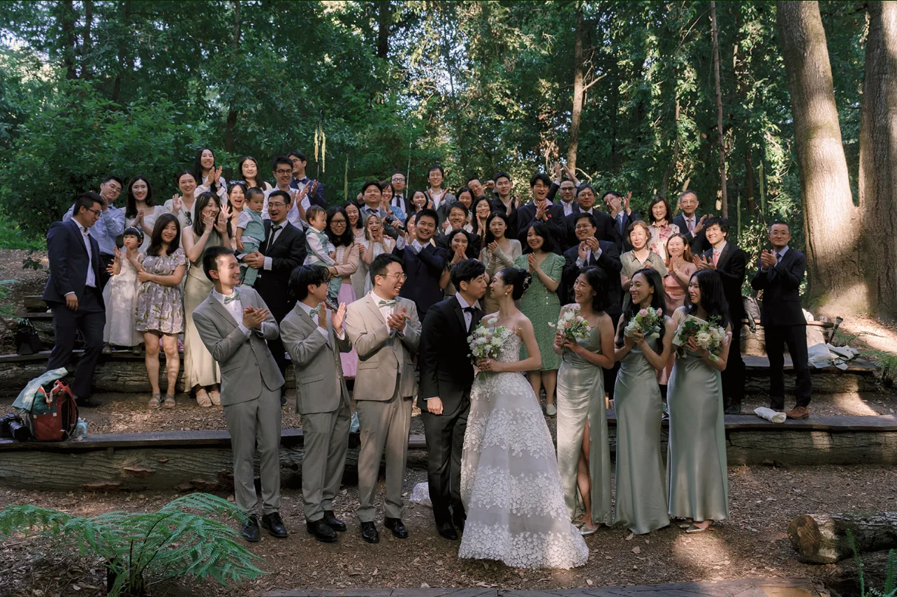 Newlyweds and their guests gathered for a joyful group portrait in the redwood grove.