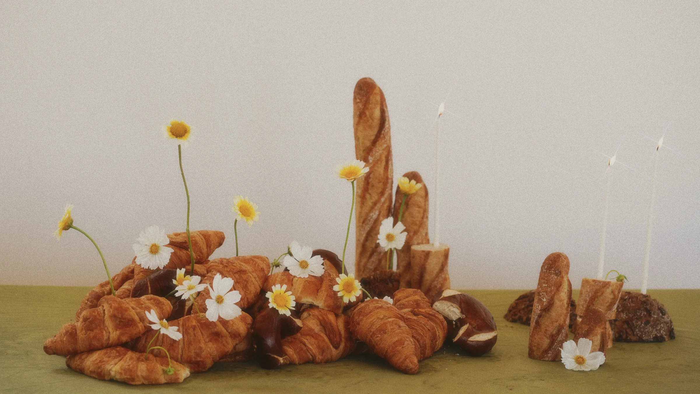 Artistic bread and croissant display accented with delicate white daisies